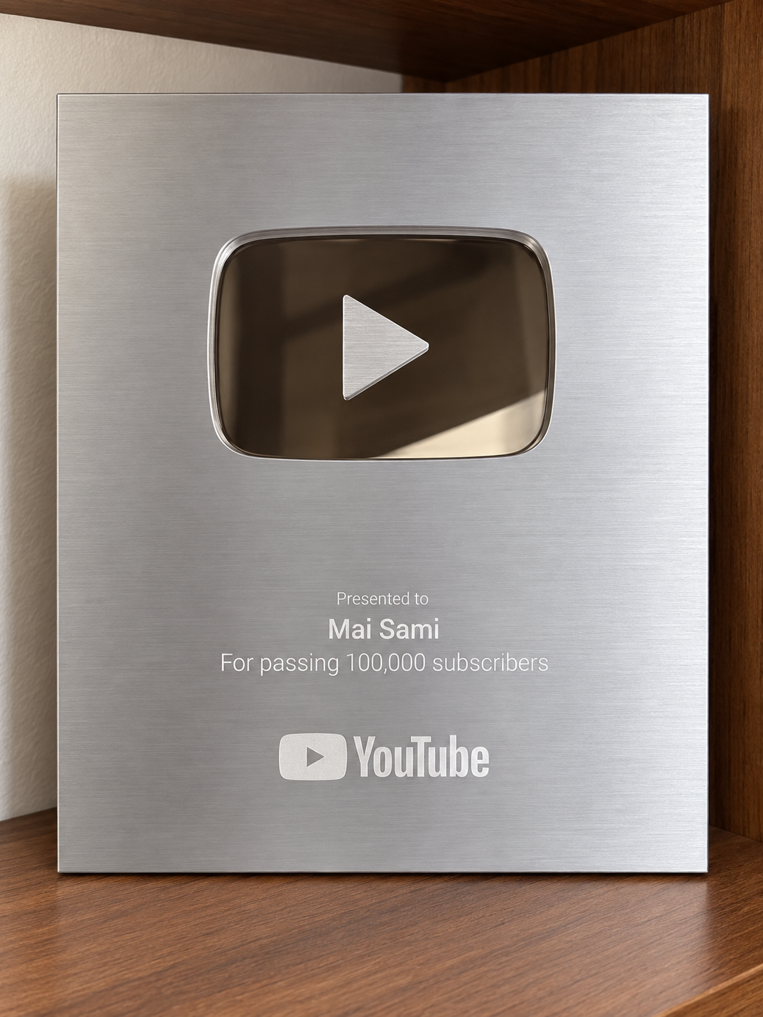 Close-up of Mai Sami's YouTube Silver Creator Award plaque for passing 100,000 subscribers