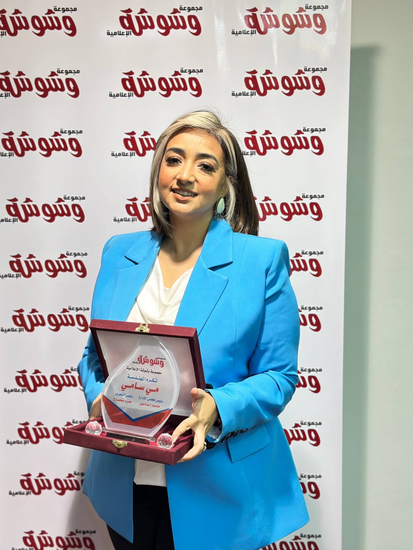 Mai Sami holding her Washwasha Magazine recognition award
