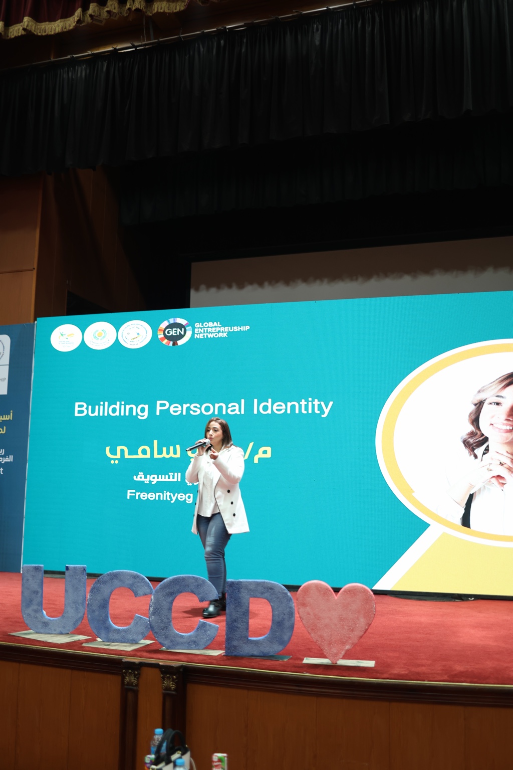 Wide stage photograph of Mai Sami delivering Building Personal Identity at UCCD Mansoura Summit
